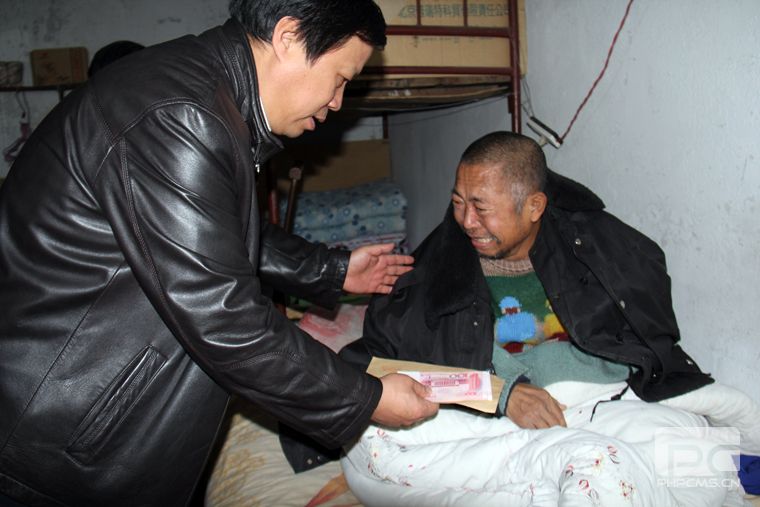 副校長王學軍把學費送到劉永強父親手中,學生家長感動地熱淚盈眶